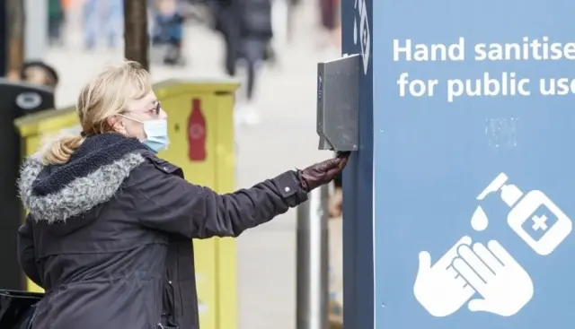 Woman using hand sanitiser