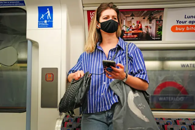 A woman wearing a mask on a Tube