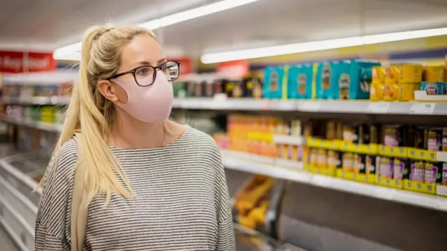 A woman wearing a face mask in a shop