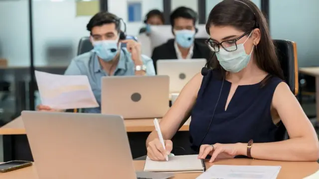 People wearing face masks in an office