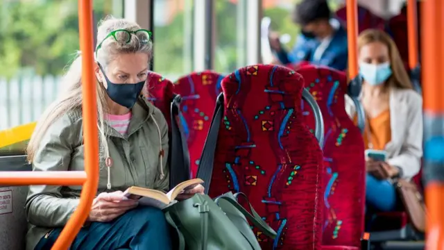 A woman wearing a mask on a bus