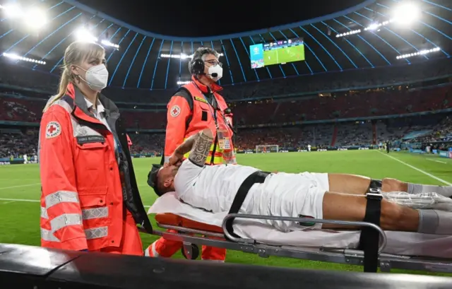 Italy's Leonardo Spinazzola leaves the field on a stretcher against Belgium