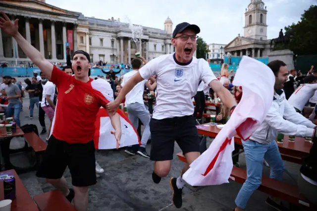 Fans celebrate at a football match viewing area