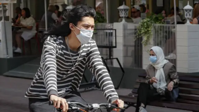 A woman rides a bike wearing a mask in Moscow