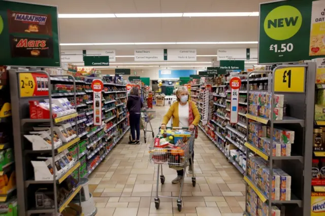 A woman wears a face mask while shopping in a supermarket