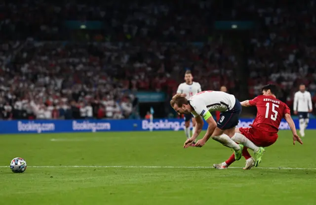 Harry Kane goes over in the box after contact with Norgaard