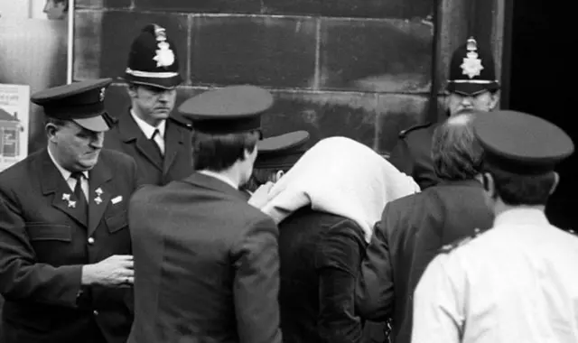 Sutcliffe entering court covered in blanket