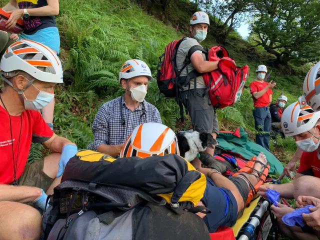 Man on stretcher surrounded by rescue team