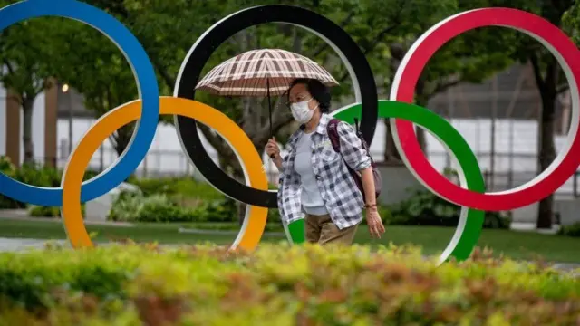 A woman walks past Tokyo Olympic Games sign