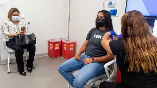 A 16-year old receives a dose of the Pfizer vaccine