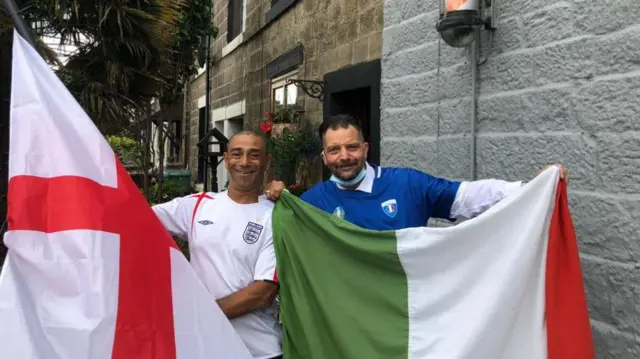 Chris Trippier holding the England flag, Nino the barber holding an Italian flag