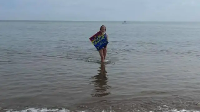 Girl in sea with banner