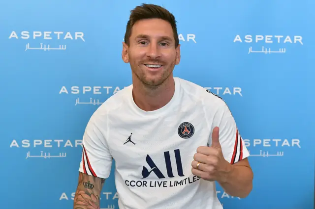 Lionel Messi giving a thumps up with a PSG shirt on