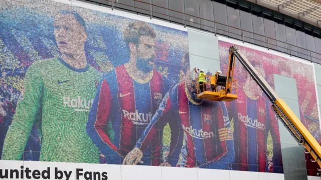 A picture of Lionel Messi is taken down outside the Nou Camp