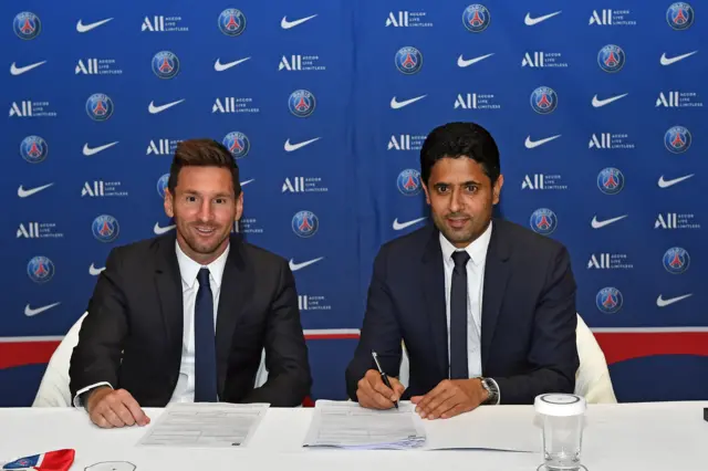 Lionel Messi and Nasser Al Khelaifi signing contracts