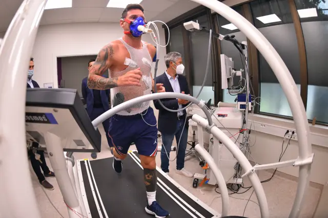 Lionel Messi on a treadmill with a mask with tubes coming out on his face