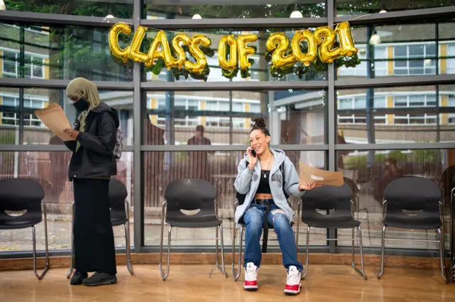 Cyan Benjamin-Neita (seated) shares news of her GCSE results by phone at Ark Burlington Danes Academy, in west London