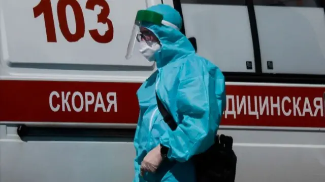 A medical specialist walks by an ambulance outside a hospital in Moscow