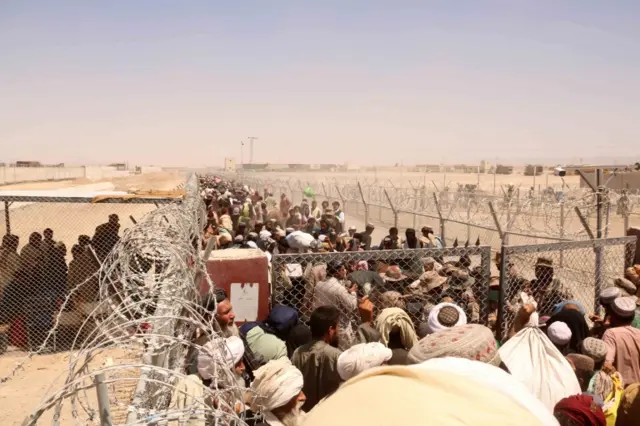 People stranded at the Pakistani-Afghan border wait to cross the border