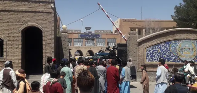 Taliban militants drive a police vehicle into a provincial government's office