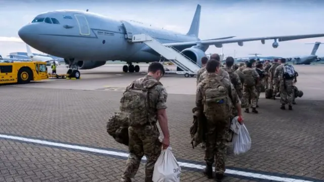 Armed forces seen about to board an aircraft in handout images