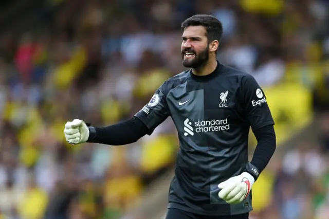 Alisson celebrates while playing for Liverpool