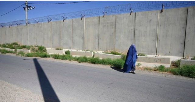 A woman walks past Bagram airbase