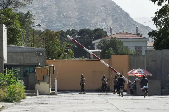 Afghan security personnel stand guard in front of a gate in the Green Zone of Kabul