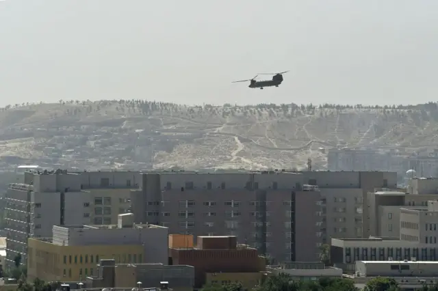 A US military helicopter is pictured flying above the US embassy in Kabul on 15 August 2021