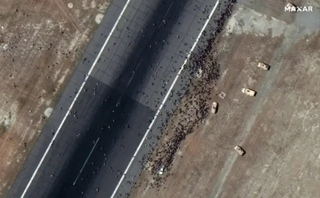 A satellite image made available by Maxar Technologies shows crowds on the tarmac of Kabul International Airport, Afghanistan