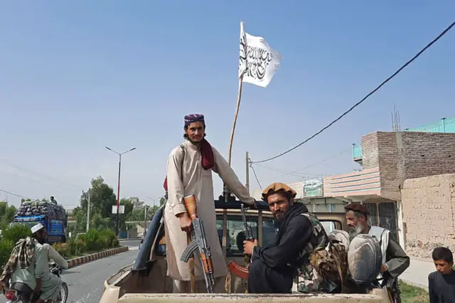 Taliban fighters drive an Afghan National Army (ANA) vehicle through the streets of Laghman province