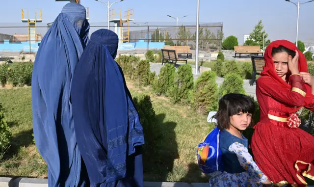 Women wearing a blue-coloured burqa along with children visit the Wazir Akbar Khan hilltop in Kabul on June 13, 2021