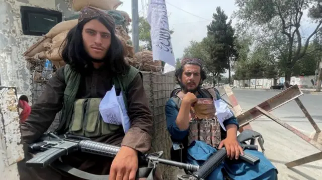 Members of Taliban forces sit at a checkpost in Kabul, Afghanistan