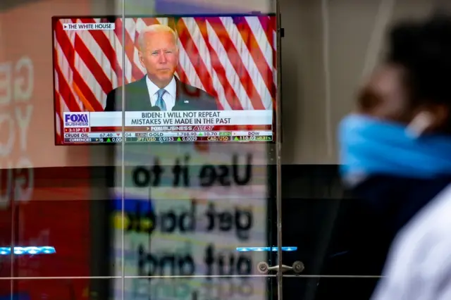 A screen displays U.S. President Joe Biden"s remarks on the crisis in Afghanistan