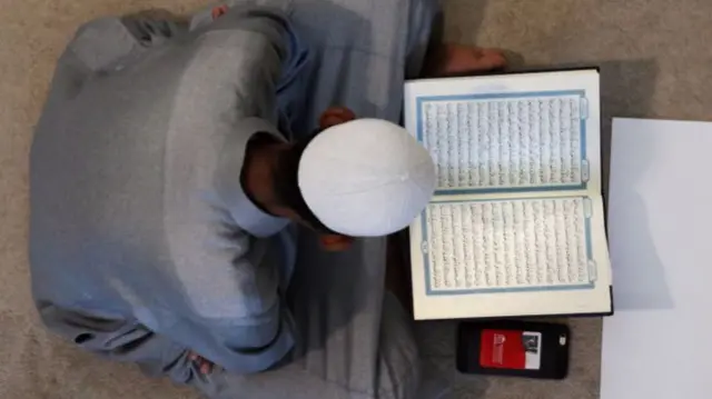 A worshipper reads the Quran, the holy book of Islam