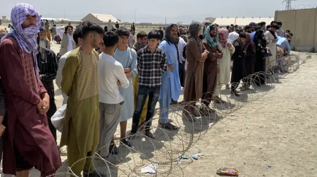 Afghans queue outside the Hamid Karzai International Airport to flee the country, after Taliban took control of Kabul, 17 August 2021