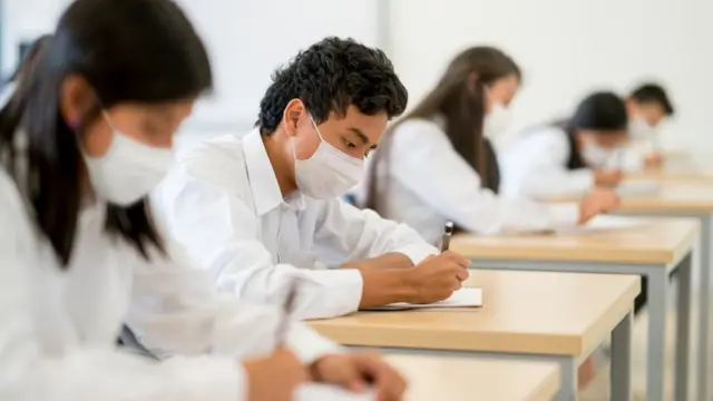 Pupils wear masks at their desks