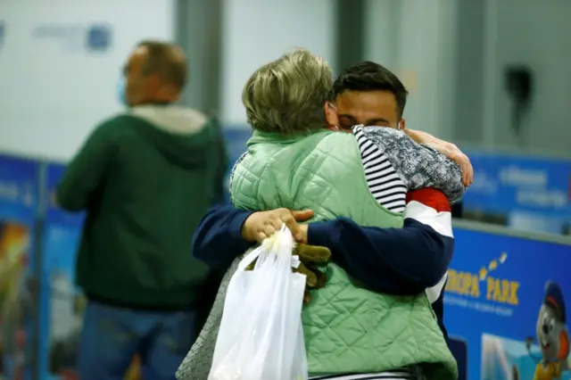 People embrace after disembarking a Lufthansa plane transporting evacuees from Kabul, Afghanistan, at the airport in Frankfurt, Germany August 18, 2021