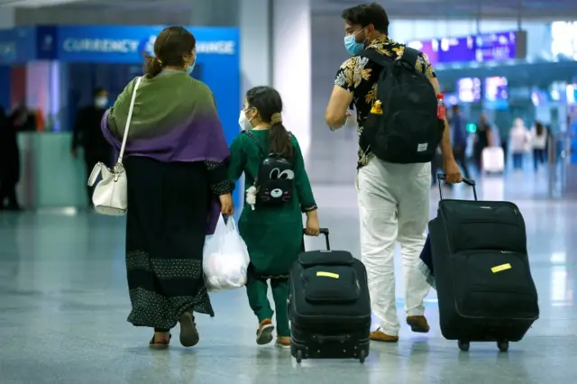 A family walks with their bags upon arrival at Frankfurt Airport, Germany, 18 August 2021