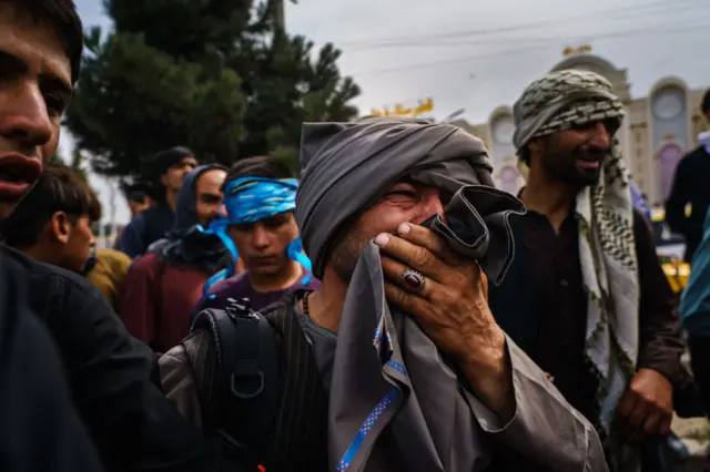 Men look on upset at scene near Kabul airport