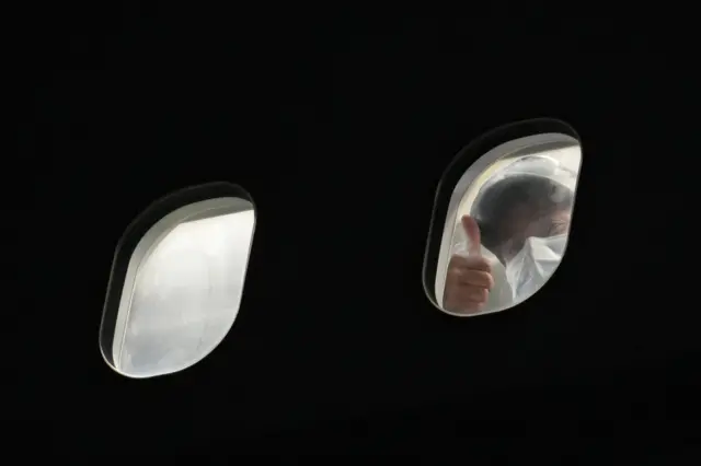 A passenger repatriated from Afghanistan gives a 'thumbs up' sign after landing on an RAF Airbus KC2 Voyager aircraft, at RAF Brize Norton, southern England, on August 17, 2021