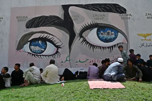 People sit outside the French embassy in Kabul