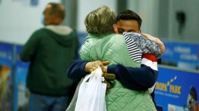 People embrace after disembarking a Lufthansa plane transporting evacuees from Kabul, Afghanistan, at the airport in Frankfurt, Germany, 18 August 2021