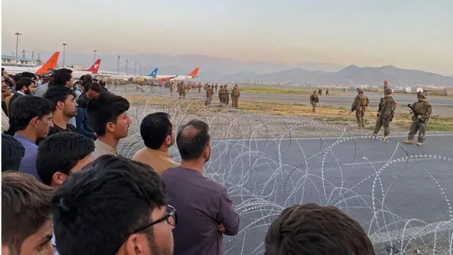 One picture showed Afghans crowding behind barbed wire near the airfield