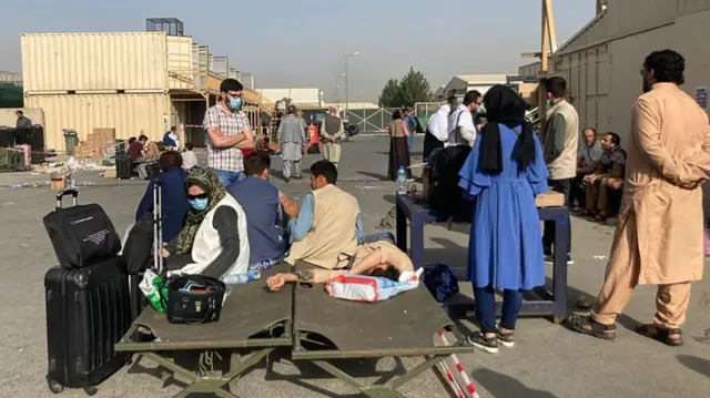 People wait to be evacuated from Afghanistan at the airport in Kabul on August 18, 2021