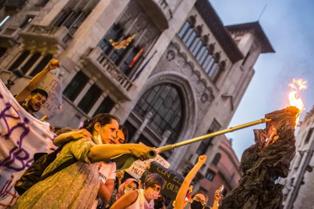 Demonstrator burning a burqa during the demonstration outside of UN offices in Barcelona