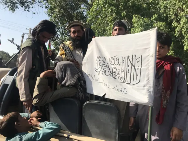 Taliban militants display their flag after taking control of Jalalabad, in Nangarhar province