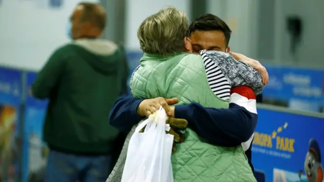 People embrace after disembarking a Lufthansa plane transporting evacuees from Kabul, Afghanistan, at the airport in Frankfurt, Germany