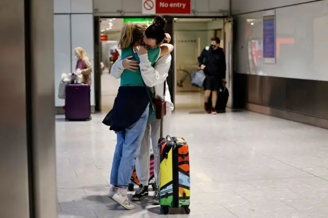 Couple embracing at Heathrow