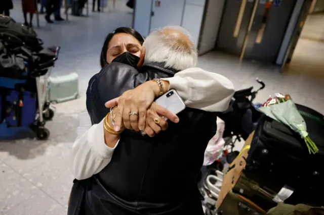 People hugging at Heathrow Airport